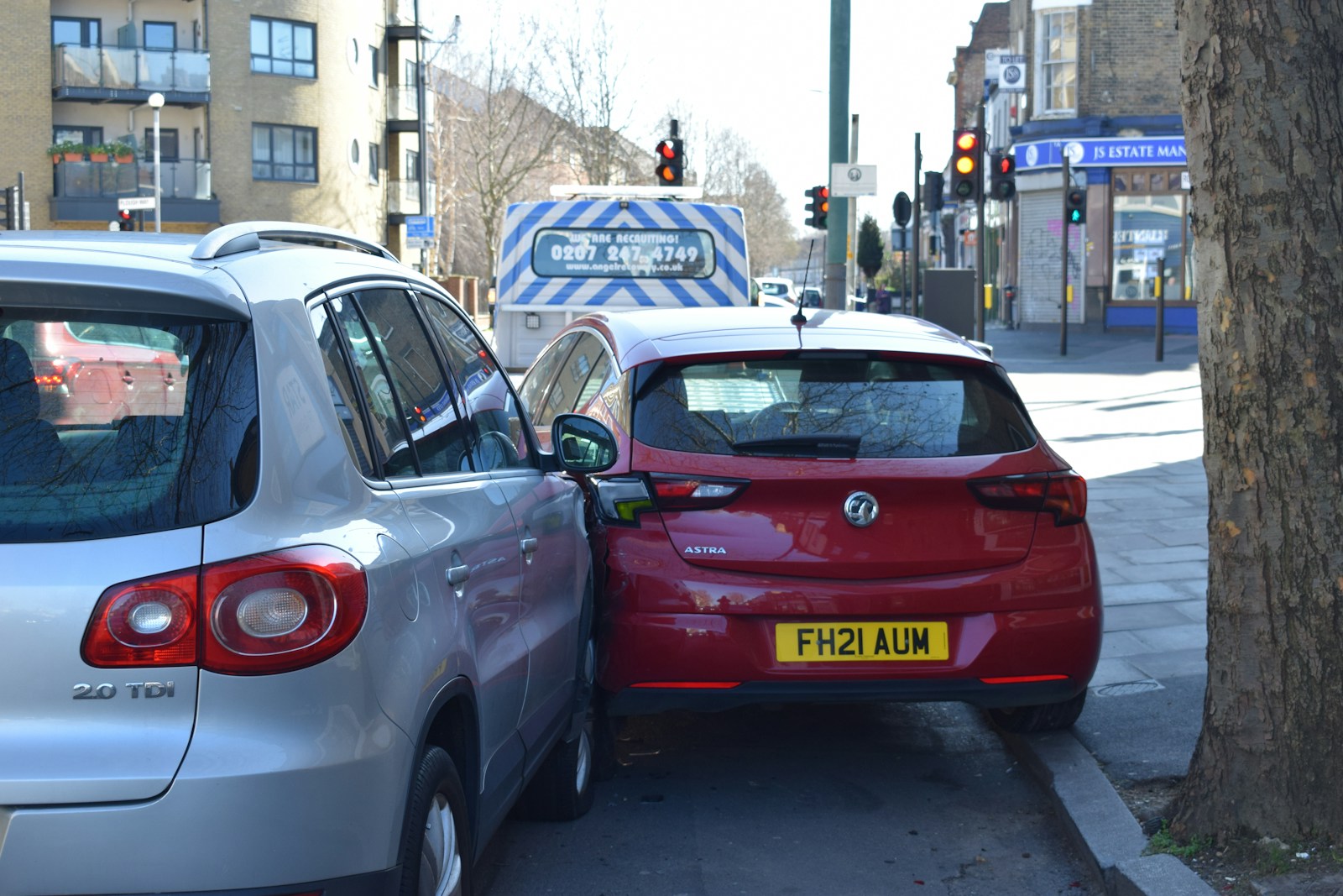 a red car is parked next to a silver car, auto
